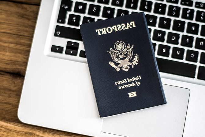 Passport sitting on a laptop keyboard.
